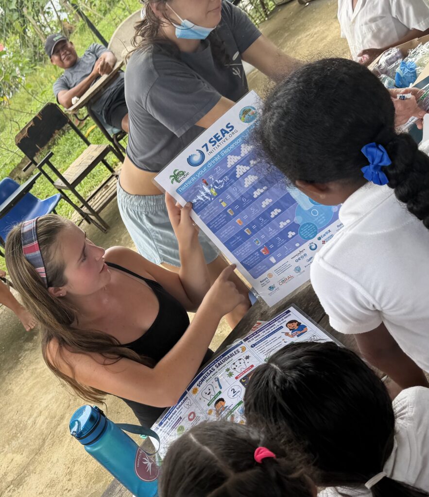 Sophia D'Angelo of the Rotary Club of Newport Beach shows schoolchildren in Bocas del Toro, Panama, a 7 Seas Initiative poster about sugary drinks