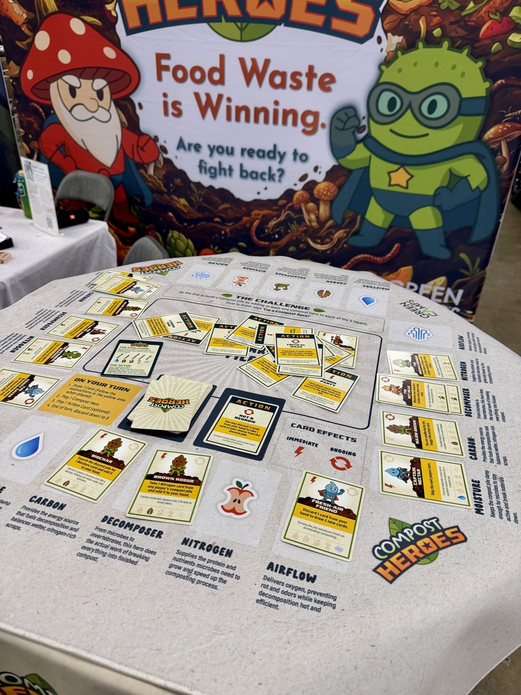 Compost Heroes play mat and cards set up at the Green Camps booth, EarthX 2026